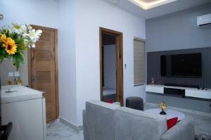 Una sala de estar con un sofá y un televisor. en Blacky's, en Lekki
