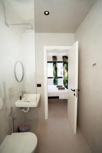 a white bathroom with a sink and a toilet at Splendida Vita in Tirane