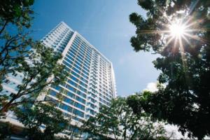a tall building with the sun in the sky at The Loop Limketkai Center 6F Condo in Pontud