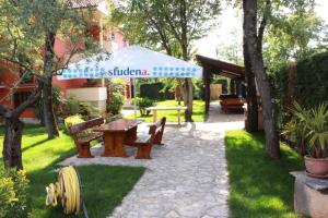 a picnic table and an umbrella in a yard at Apartments in Fiorini - Istrien 11997 in Fiorini