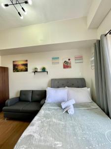 a bedroom with a bed and a couch at The Loop Limketkai Center 6F Condo in Pontud