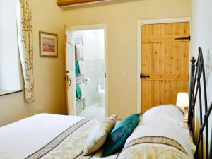 a bedroom with a bed and a bathroom at Gell Cottage in Criccieth