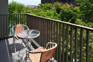 a table and two chairs on a balcony at SENS Hotel Bangkok - Kubon in Bangkok