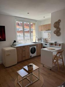 a kitchen with a sink and a stove top oven at Ambiance Bohème, Confort Cosy in Calais