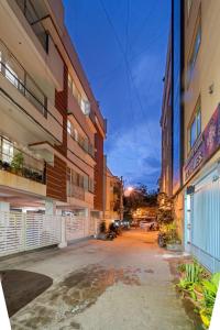 an empty street between two tall buildings at 303 Woods 2BHK Lift, Koramangala 100feet road in Bengaluru
