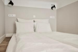 a white bed with white sheets and pillows at Standard Apartment by Hi5- Fehérhajó Studio in Budapest