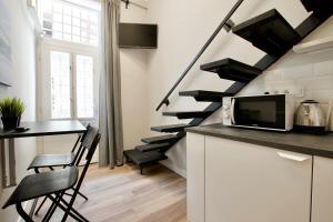 a kitchen with a counter with a microwave and a staircase at Standard Apartment by Hi5- Fehérhajó Studio in Budapest +1 photo
