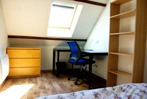 a bedroom with a desk and a window and a bed at La Vigneronne in Dijon