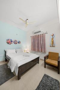 a bedroom with a large bed and a chair at 303 Woods 2BHK Lift, Koramangala 100feet road in Bengaluru