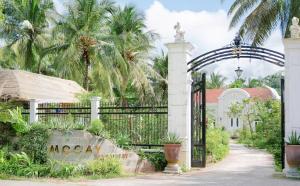 an entrance to a villa with a wrought iron gate at MOCAY farmstay in Ben Tre +36 photos