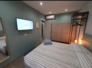 a bedroom with a bed and a flat screen tv at Playa degli Angeli Grecale in Gabicce Mare