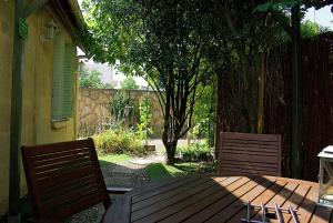 a wooden table with two chairs and a fence at La Vigneronne in Dijon