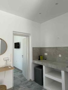 a bathroom with a counter and a sink and a mirror at Cycladic View III in Ios Chora +26 photos
