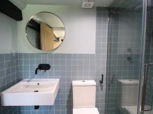 une salle de bain avec un lavabo, des toilettes et un miroir dans l'établissement Luxury 4-Bed Farmhouse Retreat in Yorkshire Dales, à Gaisgill 35 autres photos