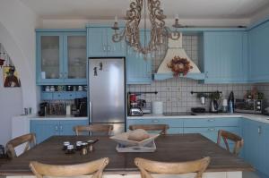 a kitchen with a wooden table and a refrigerator at Fairytale View in Karistos