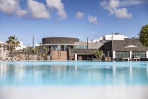 een groot zwembad voor een huis bij Caybeach Papagayos in Playa Blanca