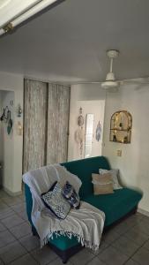 a living room with a green couch with pillows at TI BLUE plage à proximité in Les Trois-Îlets