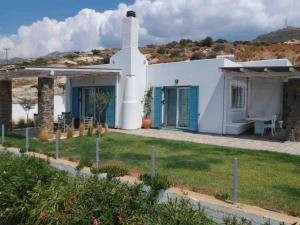 a small white house with a grass yard at Fairytale View in Karistos