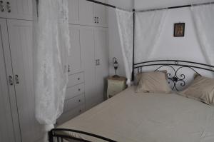 a white bedroom with a bed with a canopy at Fairytale View in Karistos
