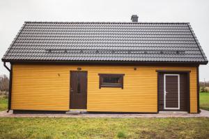 ein gelbes Gebäude mit einem Fenster und einer Tür in der Unterkunft Järve Holiday Village in Kodavere