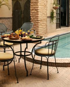 un tavolo con del cibo sopra accanto a una piscina di Marrakech Riads, Angsana Heritage Collection a Marrakech