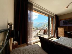een slaapkamer met een raam met uitzicht op een berg bij Alpenlodge in Zermatt