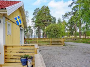 a yellow house with a flag on the side of it at Serene Seaside Retreat in Adelso-By Traum in Adelsö