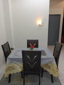 a table with chairs and a laptop on top of it at Homestay Ismail LEKIR in Sitiawan +4 photos