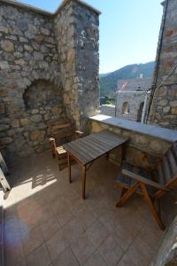 a patio with a wooden table and bench on a building at Stoneapartments, Γ ΚΩΣΤΑΛΟΣ ΚΑΙ ΣΙΑ ΟΕ in Avgonyma