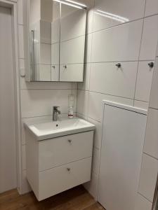 a white bathroom with a sink and a mirror at Ferienwohnung, Apartment Schwertherz in Wulfsen +5 photos
