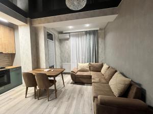 a living room with a couch and a table at Cozy apartment near Park in Tbilisi City