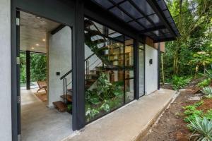 a glass extension to a house with a spiral staircase at Manuel Antonio Tree House Villas in Quepos