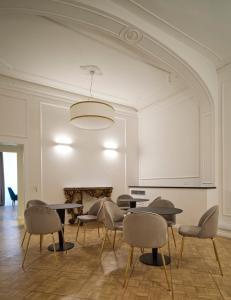 a room with tables and chairs and a white wall at Antico Palazzo Giugni - Adults Only - in Florence