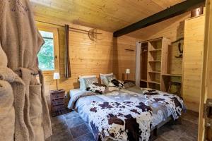 a bedroom with a bed in a wooden cabin at La Grange de Véro in Habère-Poche +59 photos