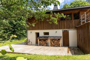 a house with a wooden deck in front of it at La Grange de Véro in Habère-Poche