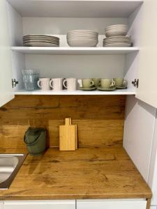 a kitchen shelf with plates and bowls on it at Apartamenty RS Kazimierza Wielka in Kazimierza Wielka +4 photos