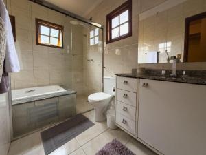 a bathroom with a tub and a toilet and a sink at Espaço gourmet e home-office na Granja in Sao Paulo +50 photos