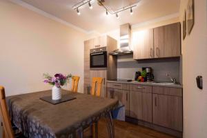 a kitchen with a table with a vase of flowers on it at _DKK1d_ Ferienwohnung Seemoewe in Niendorf