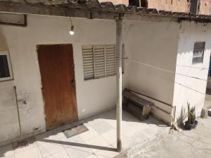 - un bâtiment avec une porte, une fenêtre et une terrasse couverte dans l'établissement Kitnet campos de são José, à São José dos Campos 2 autres photos
