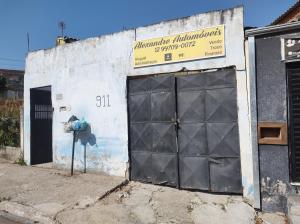 un bâtiment avec une porte de garage et une borne d'incendie dans l'établissement Kitnet campos de são José, à São José dos Campos