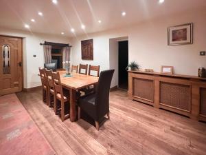 ein Esszimmer mit einem Holztisch und Stühlen in der Unterkunft Lee Cottage in Heptonstall