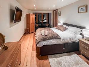 ein Schlafzimmer mit großem Bett und ein Wohnzimmer in der Unterkunft Lee Cottage in Heptonstall