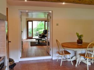 ein Esszimmer und ein Wohnzimmer mit Tisch und Stühlen in der Unterkunft Lee Cottage in Heptonstall