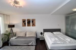a bedroom with two beds and a chandelier at Balcony Apartment - Next to Opera in Vienna