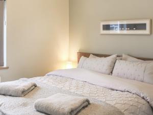 a bedroom with a bed with white sheets and pillows at South Snowdon Wharf in Porthmadog