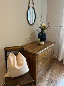a mirror sitting on top of a wooden dresser with a vase at Altstadt Residenz in Bernkastel-Kues +30 photos