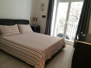ein Schlafzimmer mit einem Bett und einem großen Fenster in der Unterkunft Corsovittorio111 in Palermo