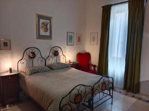 a bedroom with a bed and a red chair at Casa Zenobi in Senigallia +19 photos