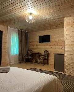 a bedroom with a bed and a flat screen tv at Ateni Hills in Gori