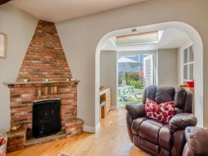 a living room with a couch and a fireplace at Curlew Cottage in Caister-on-Sea